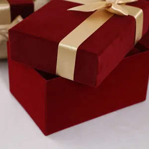 Red velvet gift box with a gold ribbon, elegant packaging detail for wedding and cosmetics.
