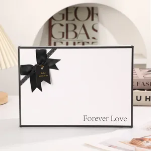 White gift box with black bow, elegant packaging box for romantic Valentine day and present.