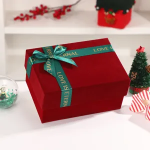 Burgundy velvet gift box detail with green ribbon bow, elegant packaging for holidays and weddings.