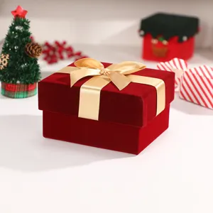 Red velvet gift box detail view with golden ribbon bow for Christmas and festive holiday present.