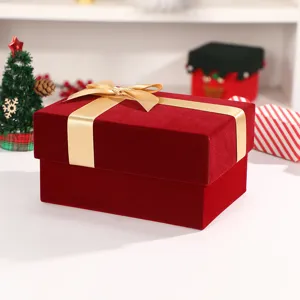 Red velvet gift box detail with luxury gold ribbon bow for holiday party and gift packaging.