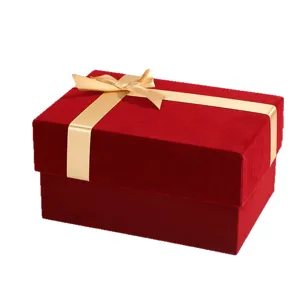 Red velvet gift box with gold ribbon bow, luxury empty packaging box for Christmas.