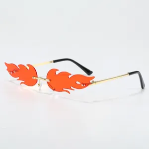 Rimless flame sunglasses featuring vibrant orange lenses and gold metal temples for trendy parties.