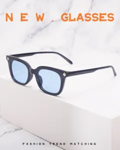 Detail shot of stylish square sunglasses with blue lenses and metal rivets on frame corners.