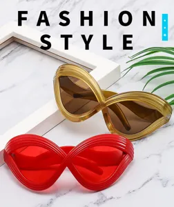 Detailed shot of futuristic exaggerated lines cat-eye sunglasses in gold and red colors.