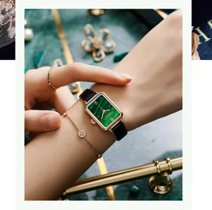 Nahaufnahme der eleganten grünen Quarz-Rechteckuhr mit schwarzem Lederarmband am Handgelenk.
