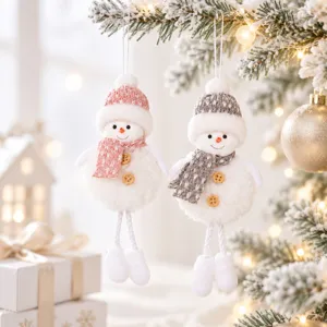 Close-up detail of plush snowman hanging ornaments with knit hat and scarf for Christmas tree.