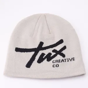Close-up detail of light grey knitted beanie featuring black jacquard lettering design.