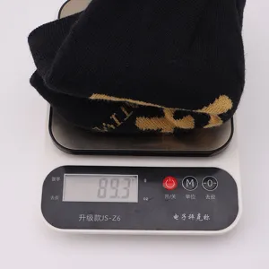 Black knitted beanie hat with yellow jacquard letters, warm winter pullover cap for daily wear.