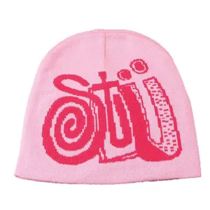 Vue en gros plan détaillée du bonnet en tricot rose avec des motifs tissés audacieux.