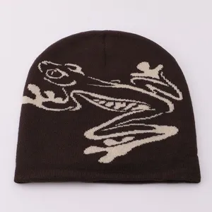 Close-up detail of the brown knit beanie featuring a stylish frog jacquard pattern design.