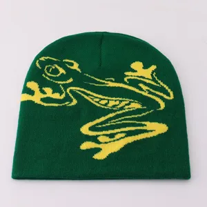 Green knitted beanie with yellow frog jacquard pattern, warm winter wool cap for casual daily wear.