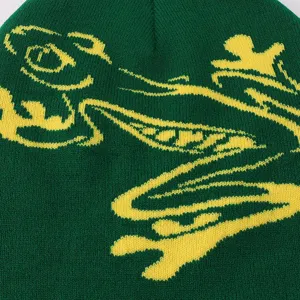 Green knitted beanie with a yellow frog pattern, warm winter casual hat detail.