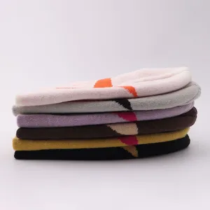 Stacked colorful knit beanie hats detail view, casual winter warm striped skull cap set.