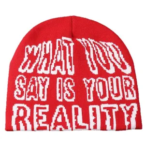 Gros plan détaillé du bonnet d'hiver rouge montrant clairement le motif de lettres blanches.
