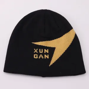 Close-up of the black knit beanie showing the unique yellow pattern and textured letter design.