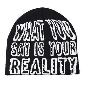 Gros plan du bonnet en tricot noir avec une typographie de texte tissée blanche bien visible.