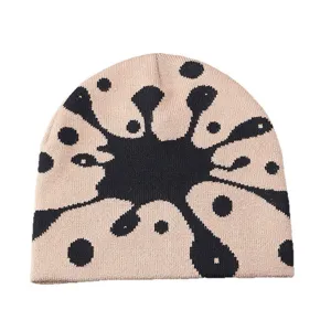 Detailed view of the stylish graffiti knit beanie featuring a unique black splatter pattern.