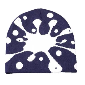 Close-up detail of the stylish paint splatter knit beanie hat, soft warm winter cap texture.