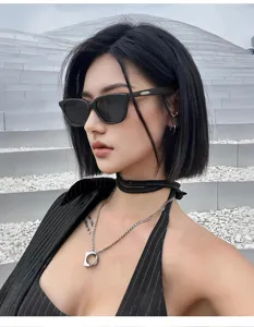 Detailed shot of fashionable black cat-eye sunglasses worn by model in urban street scene.