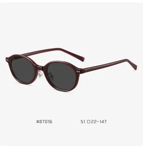 Detailed view of trendy retro small oval sunglasses with wine red TR90 frame and dark lenses.