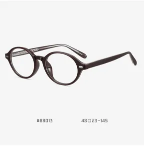 Detailaufnahme des dunkelbraunen runden TR90 Brillenrahmens mit Metallstift-Akzenten.