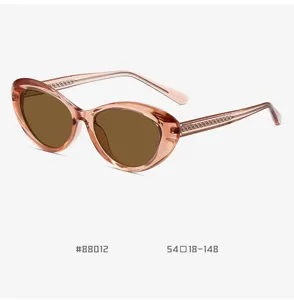 Detail view of pink cat-eye sunglasses featuring brown lenses and textured temples, stylish.
