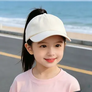Gorra de béisbol con coleta para niños vista detallada, fondo de playa al aire libre.