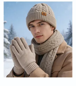 Gros plan détaillé de l'écharpe et des gants en tricot beige dans un paysage enneigé.