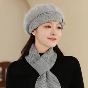 Gros plan détaillé du béret d'hiver en tricot doux et de son écharpe assortie gris clair.