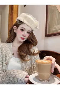 Primer plano detallado de elegante boina de lana con velo de malla y cárdigan de tweed de lujo.