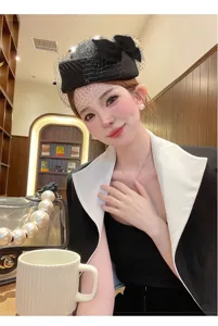 Vista detallada de sombrero de lana negra para mujer con velo de malla y lazo elegante.
