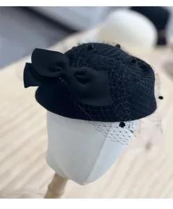Detalle de sombrero de lana negra con elegante lazo y delicado velo de red. Estilo retro.