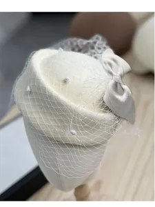Detalle de sombrero pillbox de lana, velo de malla y lazo, accesorio de mujer elegante primer plano