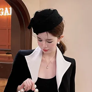 Elegante sombrero pillbox de lana negra con velo de red para mujer, accesorio de moda chic.