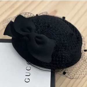 Sombrero pillbox de lana negra con elegante velo de malla y lazo, estilo británico retro.