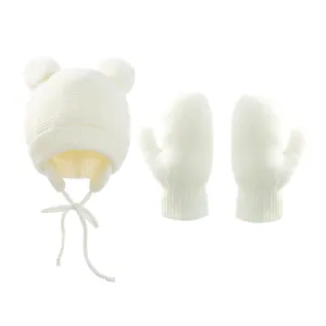 Kinder Winter warme Strickmütze und Fäustlinge Set mit Bommeln und Ohrklappen in weiß.