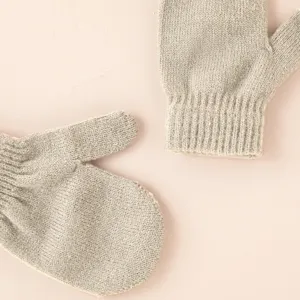 Nahaufnahme von weichen, grauen Strickfäustlingen mit feiner Textur und warmem Winterdesign.