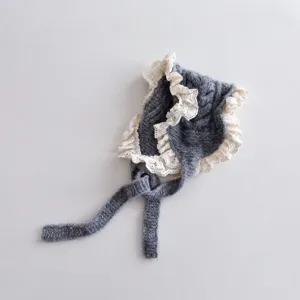 Gestrickte Babymütze mit weißer Spitze, graue Kleinkindmütze mit Bändern, Detailansicht.