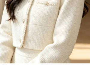 White tweed jacket detail close-up showing luxury pearl buttons and premium texture.