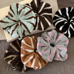 Detailaufnahme gemütlicher, gestreifter Strick-Haargummis, weiches Winter-Haaraccessoire.