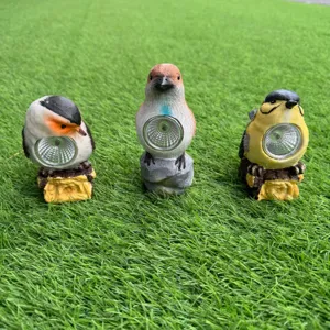 Resin solar bird garden light detail showing cute animal figurines on green turf.