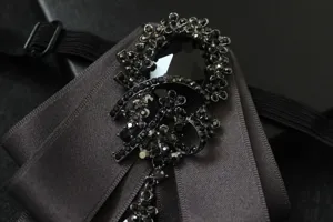 Detailed view of the multi-layer bow tie brooch with sparkling black crystals for men.