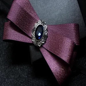 Nahaufnahme der eleganten violetten Schleife mit funkelndem blauen Schmuckstein im Zentrum.