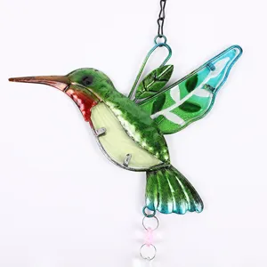 Close-up view of the colorful stained glass hummingbird suncatcher detail, garden decor piece.
