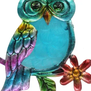 Detailed close-up of colorful metal owl hanging decor with stained glass belly and flower.