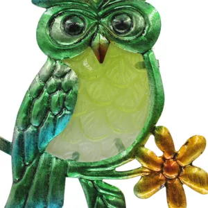 Metal owl garden hanging ornament close-up, vibrant green and yellow stained glass detail.