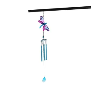 Detail shot of metal dragonfly wind chime with blue tubes and decorative hanging pendant.