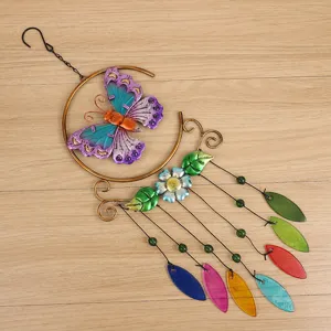 Detailed close-up view of colorful metal butterfly and glass leaf wind chime hanging decor.