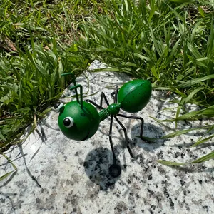 Metal ant figurine detail view, outdoor garden iron art insect ornament decoration.